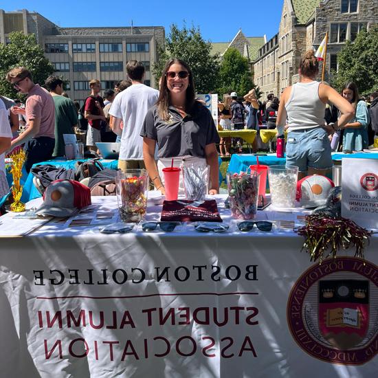 and student alumni association rep at a Student involvment fair table to promote the student alumni association