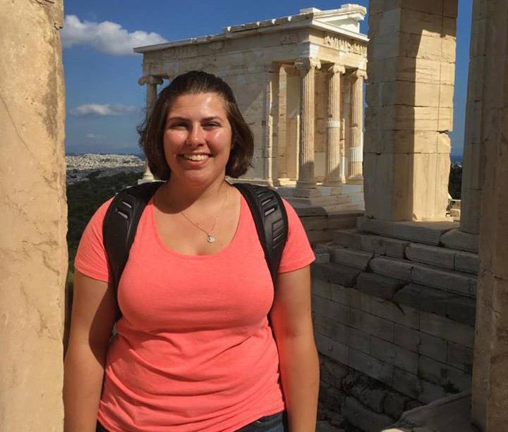 A woman standing in front of the Acropolis