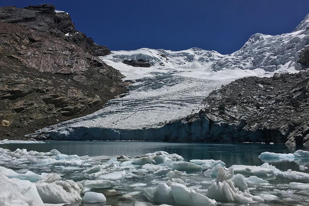 Snow covered mountains behind melted glacial ice